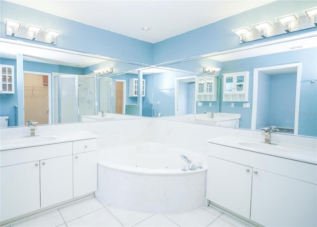 full bath with a stall shower, two vanities, a sink, and tile patterned floors