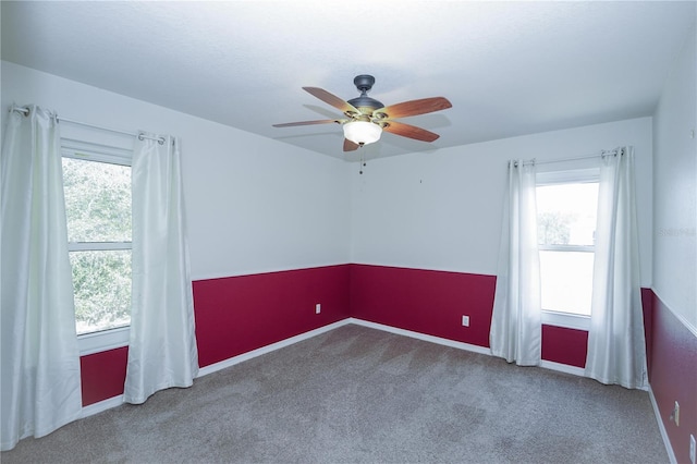empty room featuring a ceiling fan, baseboards, carpet, and plenty of natural light