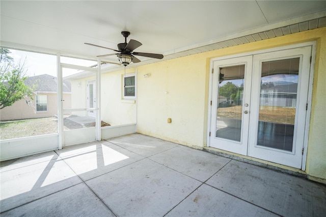 unfurnished sunroom featuring a ceiling fan and french doors