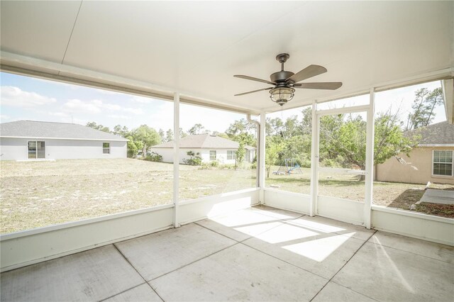 unfurnished sunroom with ceiling fan