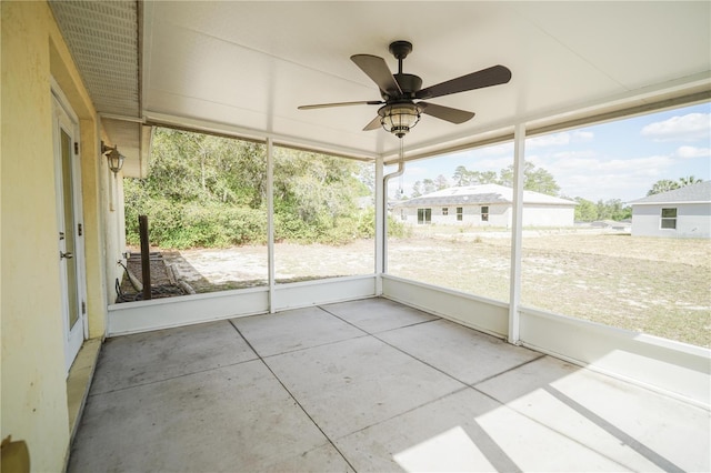 unfurnished sunroom with a wealth of natural light and a ceiling fan