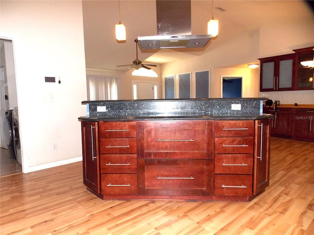kitchen featuring island range hood, light wood-style flooring, dark brown cabinets, a ceiling fan, and washer and clothes dryer