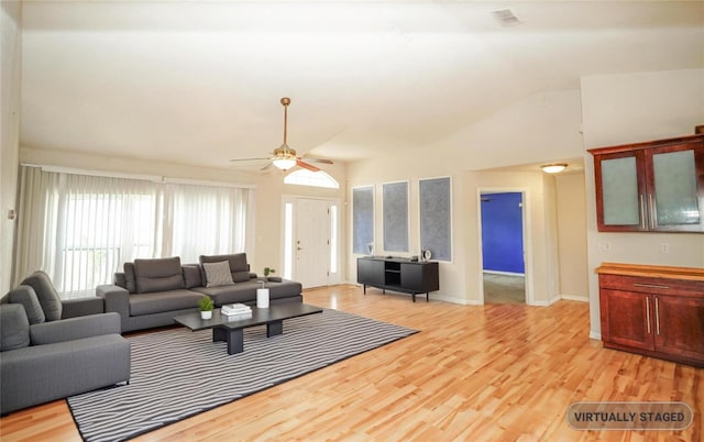living room featuring light wood-style floors, visible vents, baseboards, vaulted ceiling, and a ceiling fan