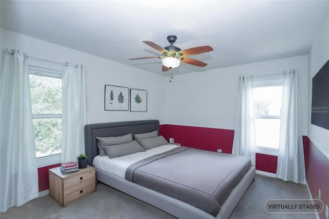 bedroom with baseboards, a ceiling fan, multiple windows, and carpet