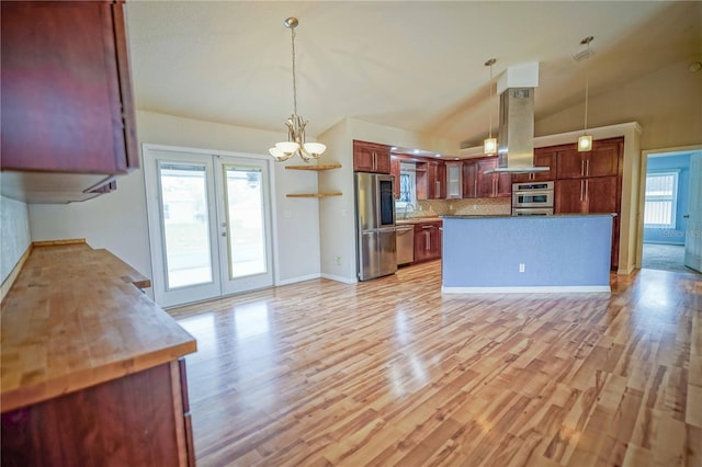 2730 SW 162nd Street Rd, Ocala, FL 34473 - kitchen with appliances with stainless steel finishes, vaulted ceiling, island range hood, tasteful backsplash, and a chandelier