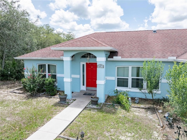 2730 SW 162nd Street Rd, Ocala, FL 34473 - view of front facade featuring roof with shingles, stucco siding, and a front lawn