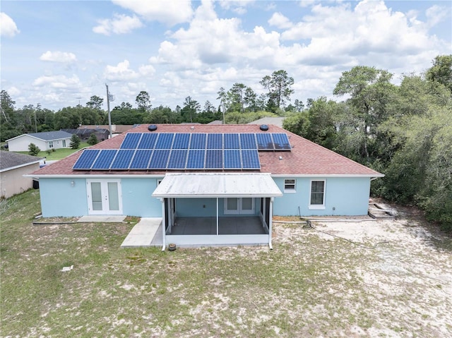 2730 SW 162nd Street Rd, Ocala, FL 34473 - rear view of house featuring french doors, a sunroom, solar panels, and a yard