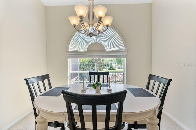 carpeted dining room featuring baseboards and an inviting chandelier