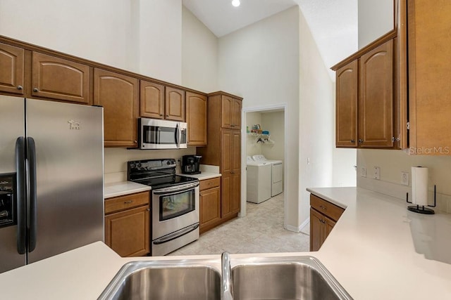 kitchen featuring light countertops, appliances with stainless steel finishes, and washer and dryer