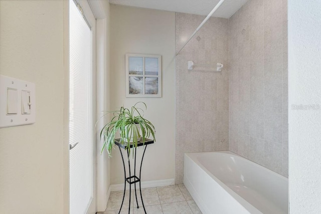full bath with baseboards, tile patterned flooring, and shower / bath combination