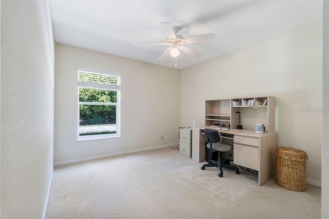 office area featuring a ceiling fan, baseboards, a textured ceiling, and light colored carpet
