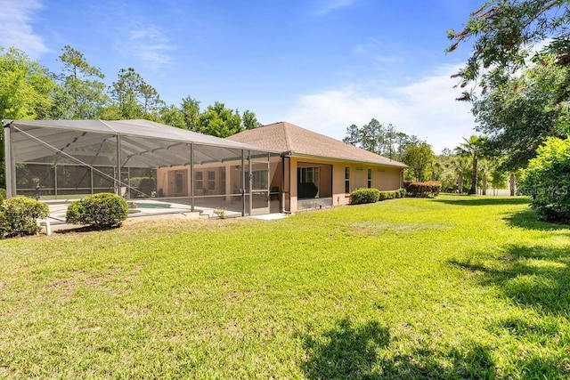 back of property featuring stucco siding, an outdoor pool, a yard, and glass enclosure