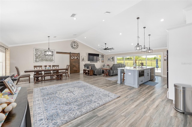 9950 NW 11th Ter, Ocala, FL 34475 - living room with a barn door, lofted ceiling, ceiling fan, light wood-style floors, and recessed lighting