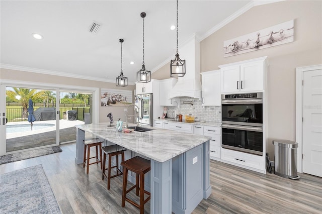 9950 NW 11th Ter, Ocala, FL 34475 - kitchen featuring stainless steel appliances, backsplash, a center island with sink, ornamental molding, and a kitchen breakfast bar