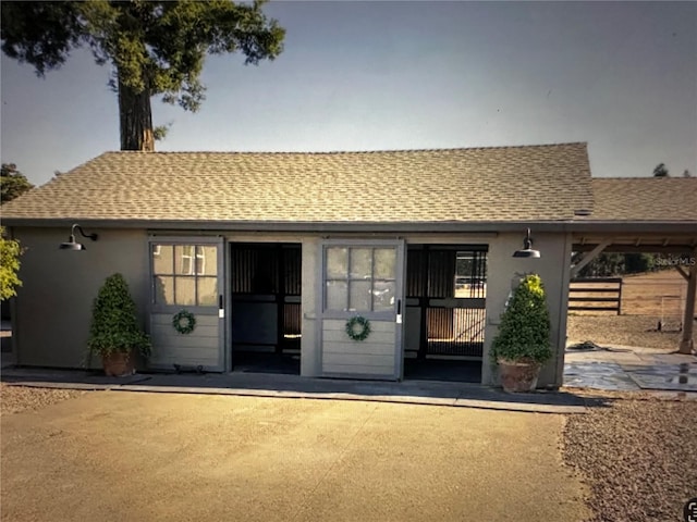9950 NW 11th Ter, Ocala, FL 34475 - view of front of house featuring roof with shingles, stucco siding, and a patio area