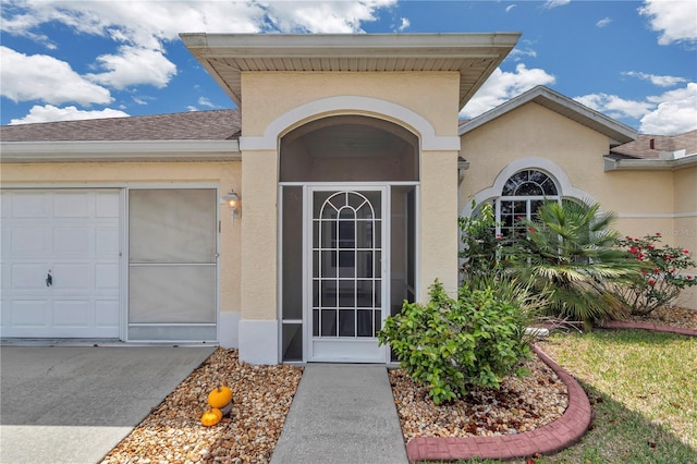 property entrance featuring an attached garage, roof with shingles, and stucco siding