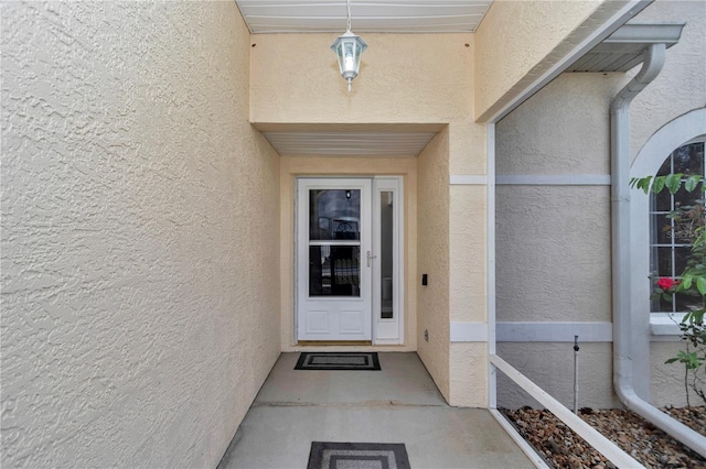view of exterior entry featuring stucco siding