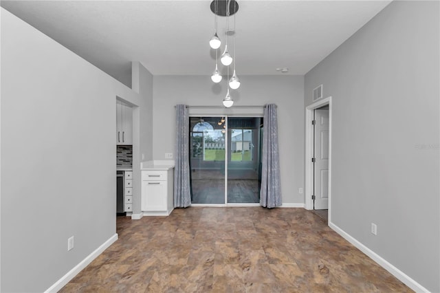 unfurnished dining area featuring visible vents and baseboards