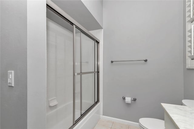 bathroom with vanity, baseboards, tile patterned floors, toilet, and bath / shower combo with glass door
