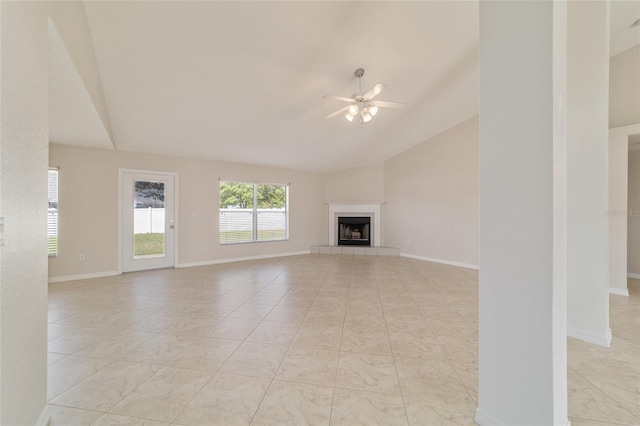 9896 SW 56th Ct, Ocala, FL 34476 - unfurnished living room featuring a tiled fireplace, baseboards, a ceiling fan, and vaulted ceiling