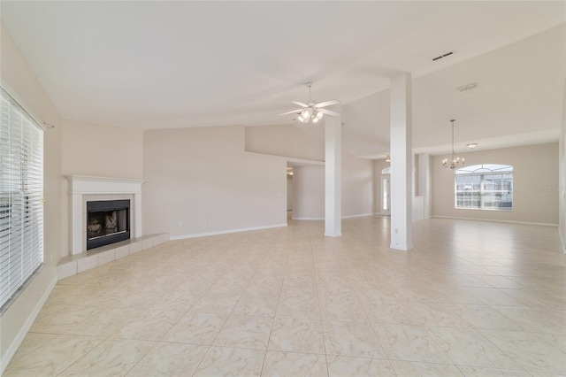 9896 SW 56th Ct, Ocala, FL 34476 - unfurnished living room featuring baseboards, vaulted ceiling, visible vents, a tile fireplace, and ceiling fan with notable chandelier