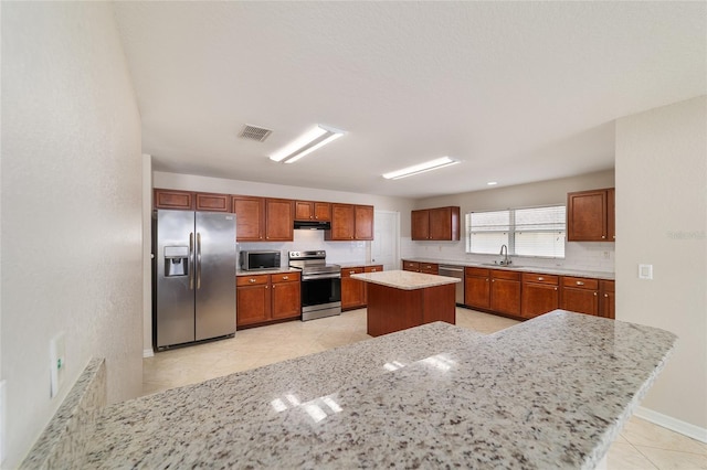 9896 SW 56th Ct, Ocala, FL 34476 - kitchen with visible vents, a center island, under cabinet range hood, a sink, and stainless steel appliances