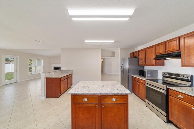 9896 SW 56th Ct, Ocala, FL 34476 - kitchen featuring tasteful backsplash, brown cabinets, appliances with stainless steel finishes, and under cabinet range hood