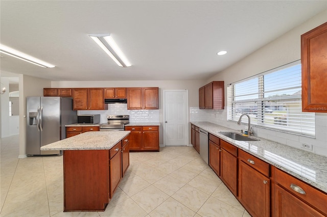 9896 SW 56th Ct, Ocala, FL 34476 - kitchen featuring a center island, under cabinet range hood, a sink, stainless steel appliances, and backsplash