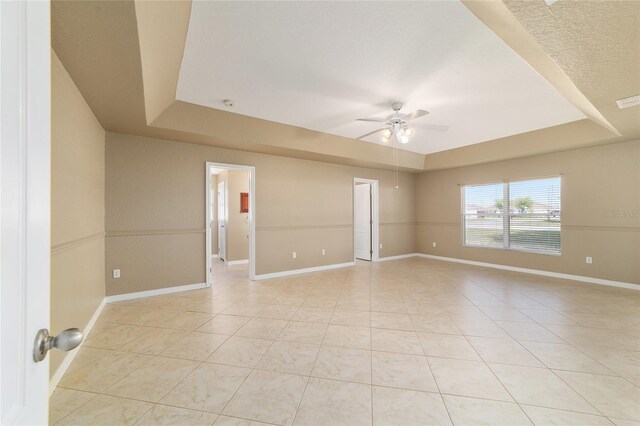 9896 SW 56th Ct, Ocala, FL 34476 - unfurnished room featuring a tray ceiling, a ceiling fan, and light tile patterned floors