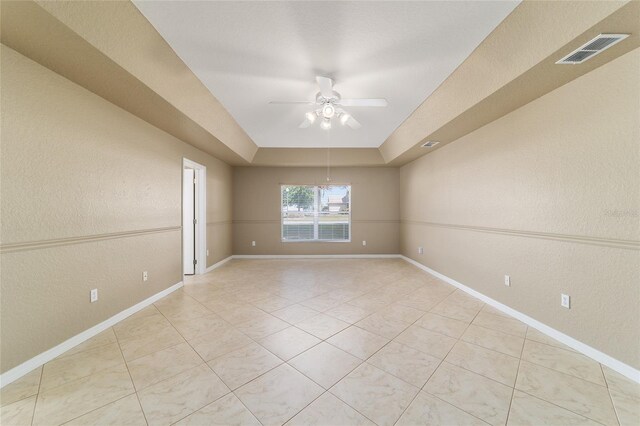 9896 SW 56th Ct, Ocala, FL 34476 - unfurnished room with visible vents, baseboards, a raised ceiling, a ceiling fan, and light tile patterned flooring