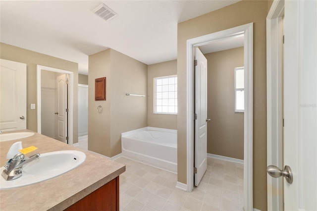 9896 SW 56th Ct, Ocala, FL 34476 - bathroom featuring a bath, visible vents, a sink, double vanity, and baseboards