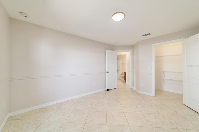 9896 SW 56th Ct, Ocala, FL 34476 - unfurnished bedroom with a closet, a walk in closet, light tile patterned floors, and baseboards