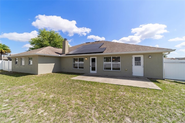 9896 SW 56th Ct, Ocala, FL 34476 - rear view of property featuring a yard, stucco siding, a patio area, fence, and solar panels