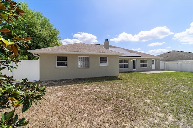 9896 SW 56th Ct, Ocala, FL 34476 - back of property featuring a yard, a fenced backyard, stucco siding, roof with shingles, and a patio area
