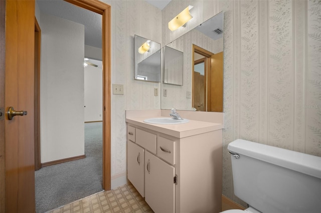bathroom featuring wallpapered walls, toilet, vanity, tile patterned floors, and ceiling fan