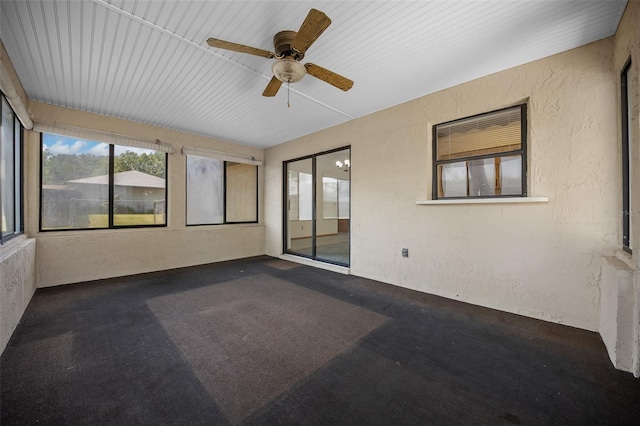 empty room featuring healthy amount of natural light, ceiling fan, and a textured wall