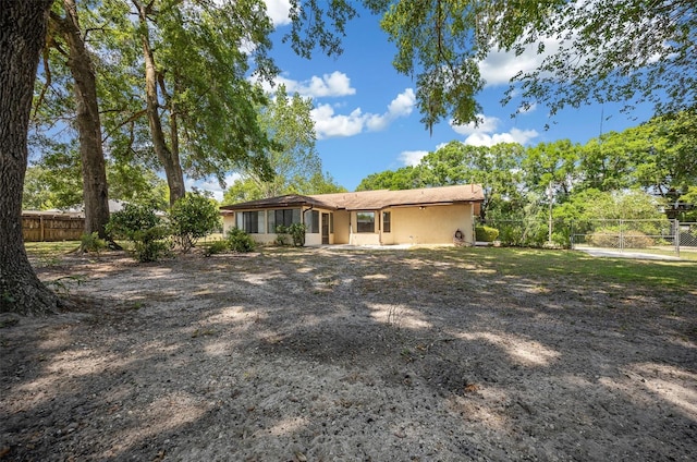 rear view of property featuring a fenced backyard and stucco siding