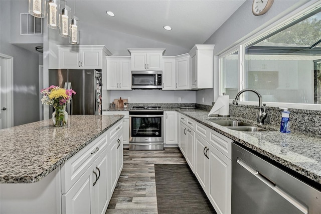 7407 SW 202nd Ct, Dunnellon, FL 34431 - kitchen featuring appliances with stainless steel finishes, vaulted ceiling, wood finished floors, white cabinets, and light stone countertops