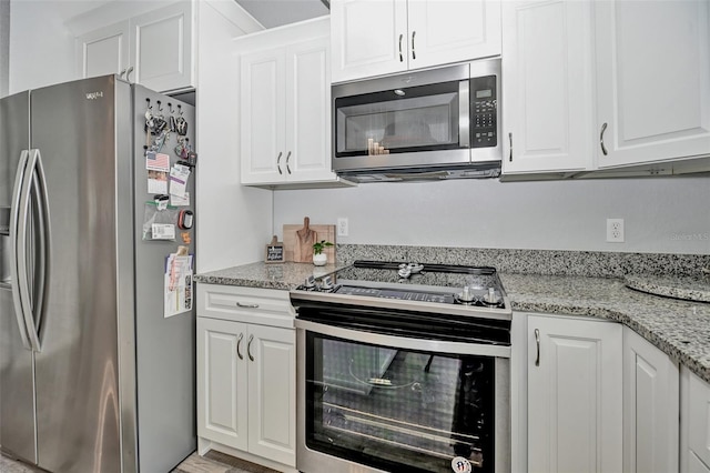 7407 SW 202nd Ct, Dunnellon, FL 34431 - kitchen with stainless steel appliances, white cabinets, and light stone counters