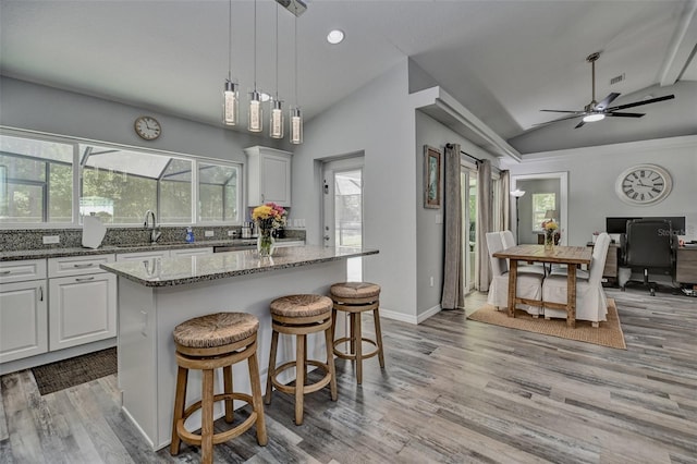 7407 SW 202nd Ct, Dunnellon, FL 34431 - kitchen with vaulted ceiling, light wood-style flooring, stone counters, a center island, and white cabinets