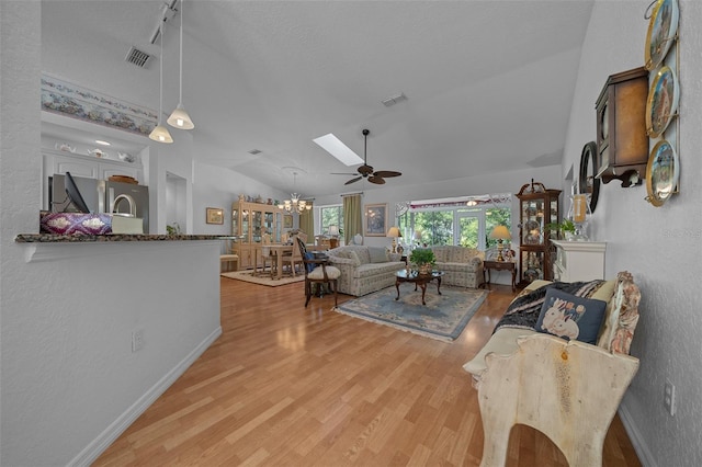 7692 SW 117th Street Rd, Ocala, FL 34476 - living area with visible vents, lofted ceiling with skylight, wood finished floors, and ceiling fan with notable chandelier