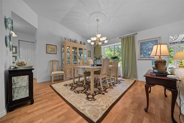 7692 SW 117th Street Rd, Ocala, FL 34476 - dining area with light wood-style flooring, an inviting chandelier, baseboards, and lofted ceiling