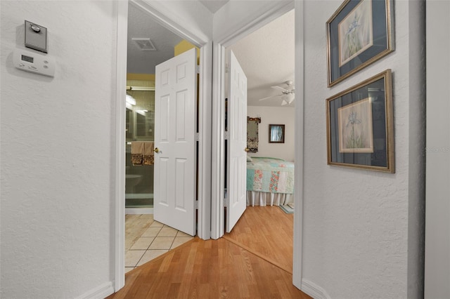 7692 SW 117th Street Rd, Ocala, FL 34476 - hall featuring a textured wall, visible vents, baseboards, and wood finished floors