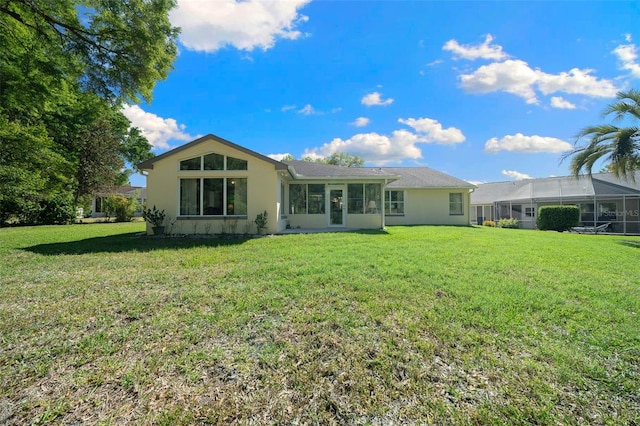 7692 SW 117th Street Rd, Ocala, FL 34476 - back of property featuring a sunroom, a yard, and stucco siding