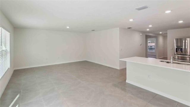 interior space featuring recessed lighting, baseboards, visible vents, and a sink