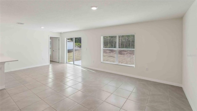 unfurnished room featuring baseboards and light tile patterned flooring