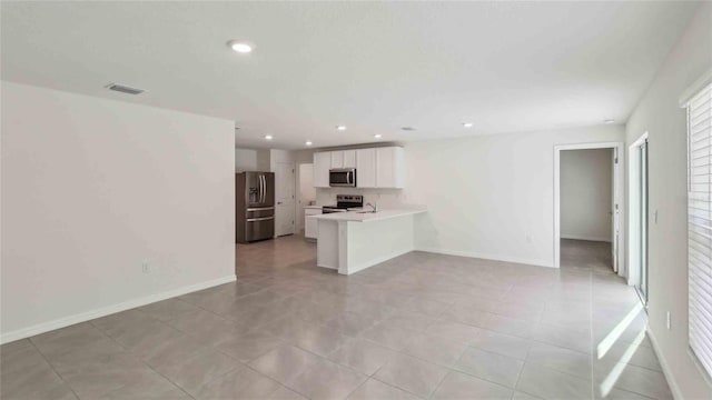 unfurnished living room featuring light tile patterned floors, baseboards, recessed lighting, and visible vents