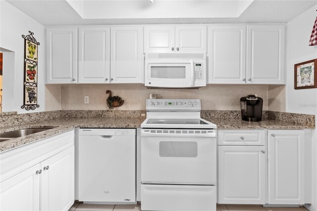 2756 Clubhouse Dr Unit 101, Sarasota, FL 34232 - kitchen featuring light stone countertops, white appliances, and white cabinets