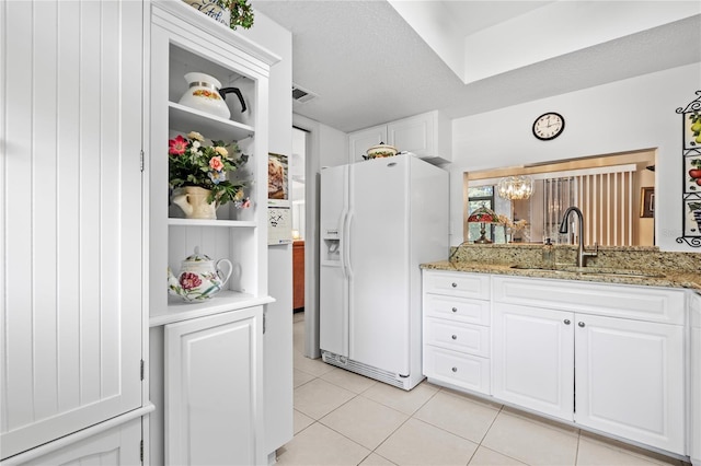 2756 Clubhouse Dr Unit 101, Sarasota, FL 34232 - kitchen featuring visible vents, white cabinets, white fridge with ice dispenser, a sink, and light tile patterned flooring
