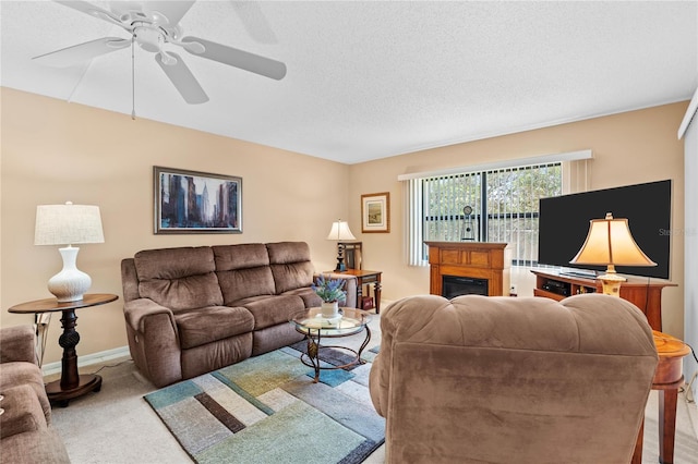 2756 Clubhouse Dr Unit 101, Sarasota, FL 34232 - carpeted living area featuring a textured ceiling, ceiling fan, baseboards, and a glass covered fireplace